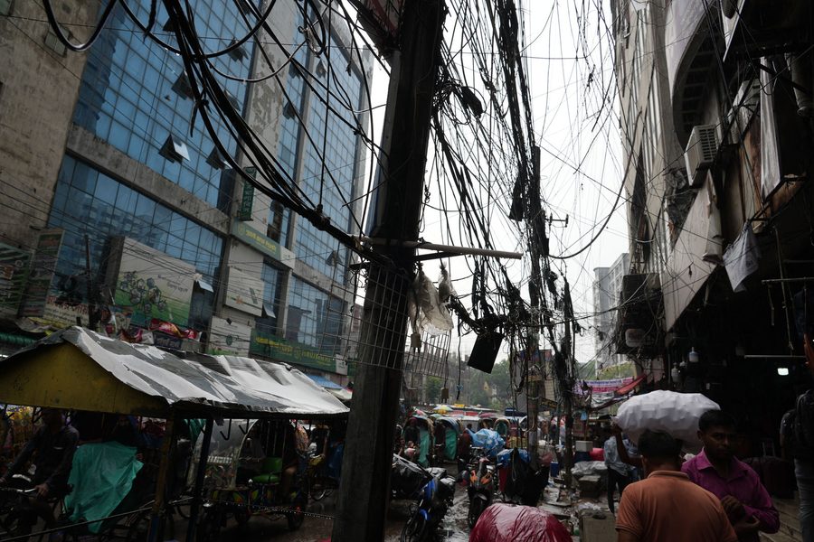 Tangled overhead power lines on a busy street