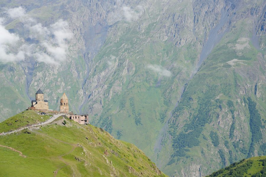 Gergeti Trinity Church against the massive mountain walls