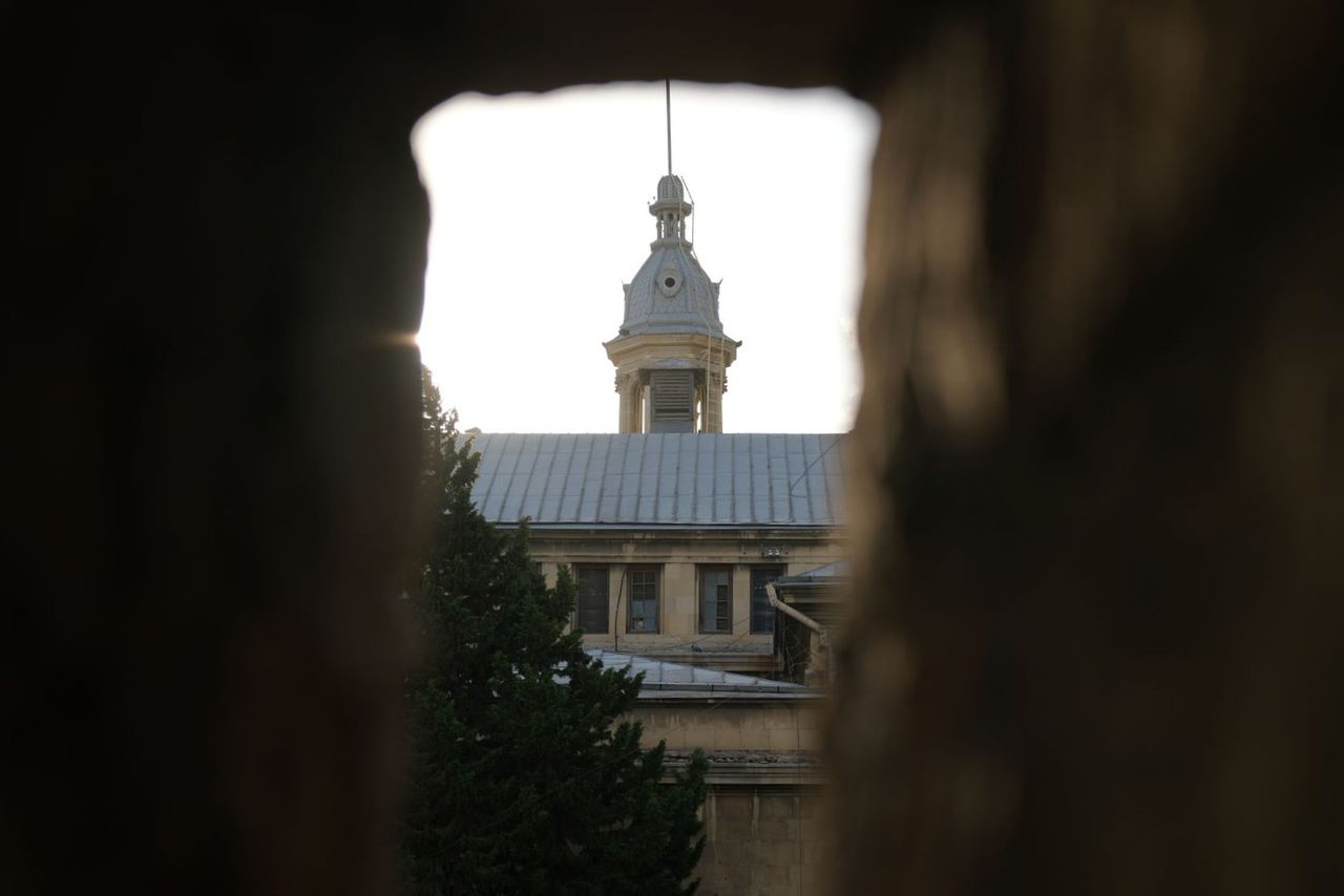 Tbilisi State University through a stone wall gap