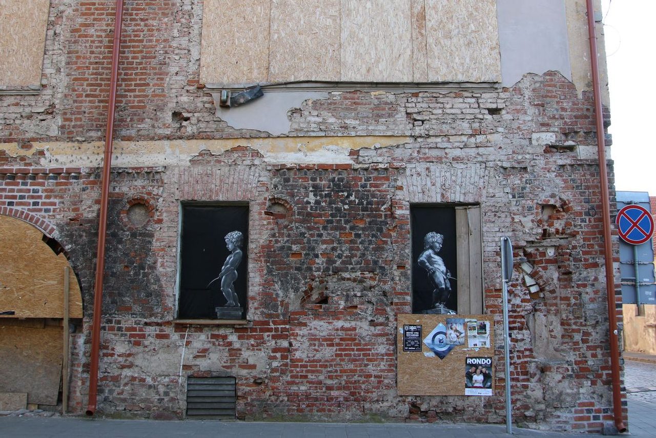 Banksy-inspired stencil art on a weathered brick wall