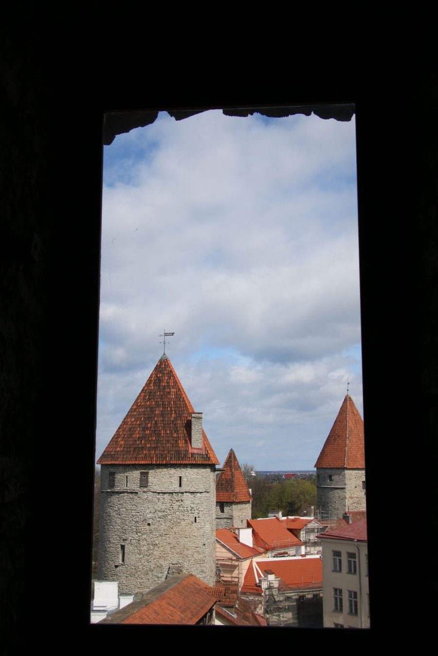 The medieval towers framed by a stone window.